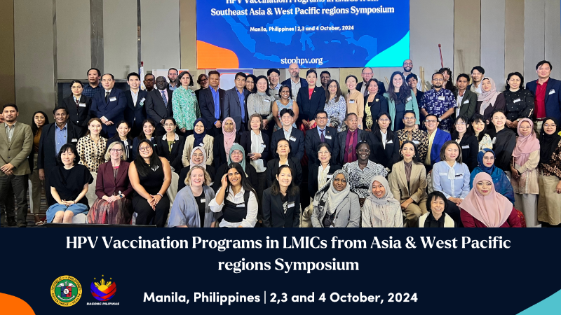 conference attendees standing in front of sign