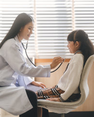 Southeast asian doctor woman using stethoscope check little girl health care in kid clinic examining room. People at hospital and medical center concept.